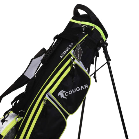 A black golf bag with neon green accents stands upright featuring multiple zippered pockets and an attached tag displaying the brand name Cougar and the model XTREME 6.5.