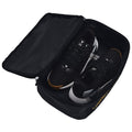 A pair of black athletic shoes is placed inside an unzipped black bag showcasing a smooth interior with a branded logo on the side reflecting a sports theme and functionality.