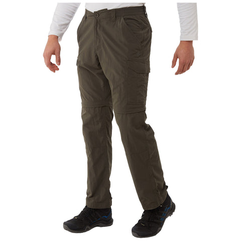 Cargo pants in an olive green color are worn by a person standing in a neutral pose wearing black hiking shoes and a white long-sleeve shirt in a plain background.