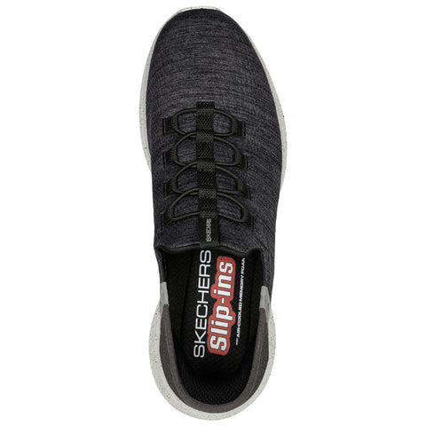 A black Skechers slip-on shoe is displayed, featuring elastic laces and a textured fabric upper. It is set against a plain white background designed for showcasing footwear.