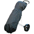 A black golf bag cover is draped over a golf cart with a handle and one wheel visible the cover protects the bag from rain or dirt while stationary.