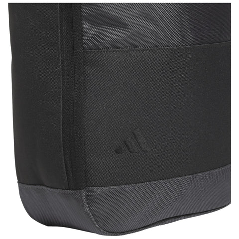 A black sports bag made of durable fabric features a textured surface and a gray base The bag showcases a subtle three-stripe logo on its side