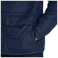 A navy puffer jacket features a front pocket with black buttons and a hand resting in another pocket, set against a plain white background.