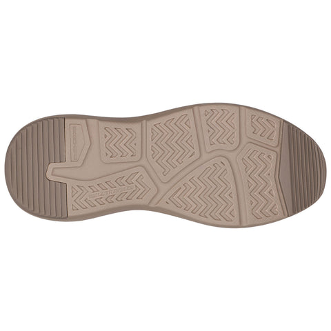 A shoe sole with a textured pattern is positioned flat against a light background showcasing grooves and ridges designed for grip and traction in outdoor contexts.