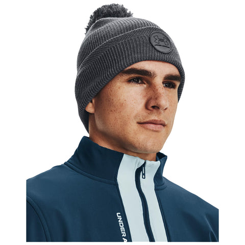 A young man with a beanie and a zippered athletic jacket gazes confidently forward. The background is plain white, emphasizing his focused expression and sporty attire.