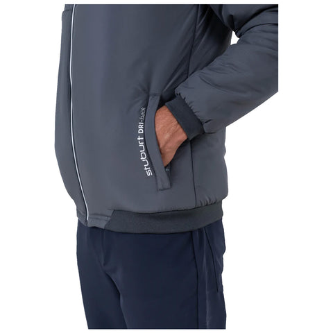 A gray padded jacket with a zipper is worn by a person who has their right hand in the pocket while standing against a neutral background. The left side displays a brand logo.