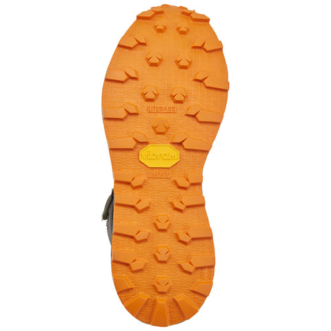 A rugged orange Vibram sole features a textured gripping pattern designed for traction. It is positioned flat, showcasing its detailed grooves and design for outdoor activities.