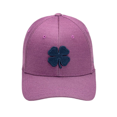 A purple baseball cap features a dark navy four-leaf clover logo prominently on the front it rests flat with a curved brim in a simple background