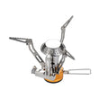 A compact camping stove features a metal burner with extendable arms for stability and heat distribution placed on a round yellow fuel canister situated in a plain background.