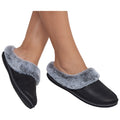 Black slippers with a gray fur lining are being worn on bare feet, showcasing a comfortable indoor footwear option, suitable for relaxing at home.