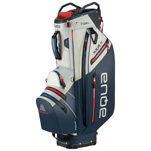 A golf bag stands upright with multiple zippers and pockets. The bag features a mix of white and navy blue colors with red accents, designed for carrying golf clubs and accessories.