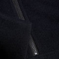 Black fabric with a textured surface features a visible zipper partially open at the edge suggesting an outerwear garment in a neutral background that highlights the material's softness and detail.