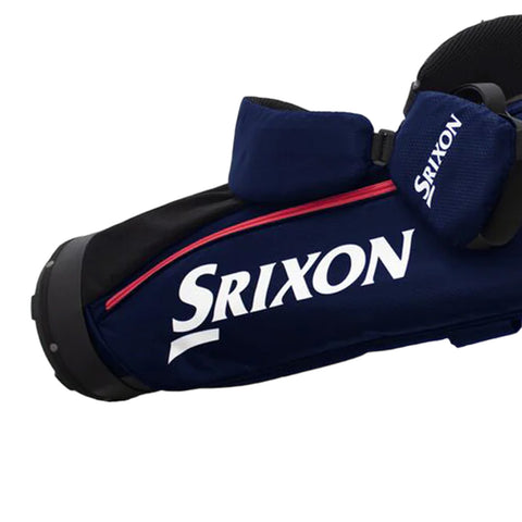 A golf bag in dark blue material features a prominent white Srixon logo and red zipper accents with a cushioned strap on top for carrying equipment on the course.