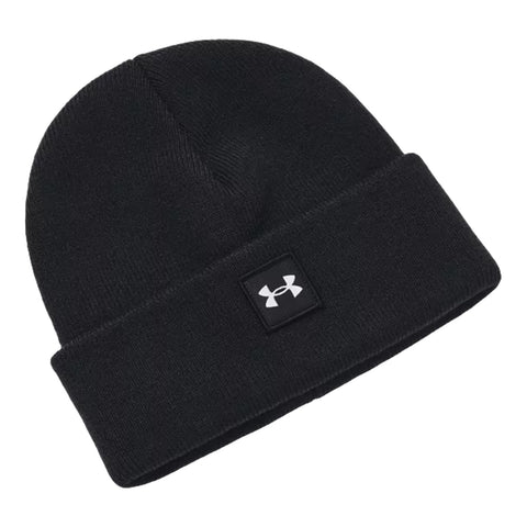 A black knit beanie lies flat showcasing a folded cuff and a square logo patch with white branding positioned at the front providing warmth and style in cold environments.