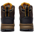 Brown high-top shoes are positioned upright showcasing their textured fabric and rubber soles highlighting a yellow interior and contrasting stitching against a dark background