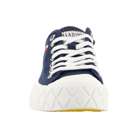 A navy blue sneaker with white laces is positioned centrally facing forward its chunky white sole has a textured surface highlighting a sporty design in a plain background