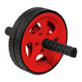 A black and red ab roller rests on a flat surface featuring a large rubber tire design and two textured handles extending from each side for grip during exercise.