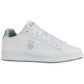 A white sneaker with a green accent features a logo on the side and is positioned against a plain background showcasing its clean design and casual style.