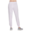 Light purple jogger pants are standing upright showing a tight waistband and tapered cuffs the wearer is also in athletic shoes in a neutral environment