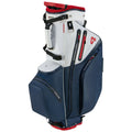 A golf bag stands upright featuring a waterproof design with multiple zippers and pockets in contrasting white and navy colors set against a plain background