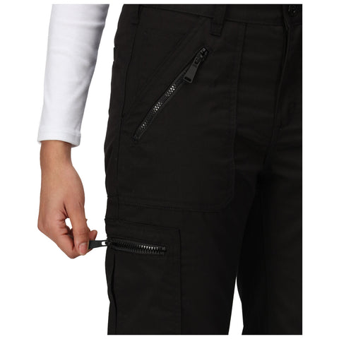 A hand grips the zipper of a black cargo pant's pocket while wearing a long-sleeve white shirt in a neutral setting, indicating the action of opening or closing the pocket.