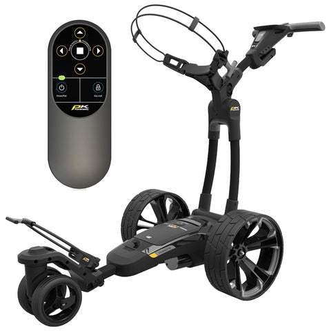 A modern golf trolley with large wheels is parked, equipped with a remote control featuring buttons for operation and settings, designed for ease of use on a golf course.