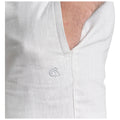 A light-colored fabric with a visible pocket is shown featuring a subtle embroidered design on the exterior. The fabric appears textured, suggesting a casual garment.