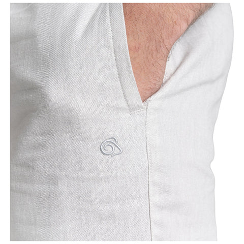 A light-colored fabric with a visible pocket is shown featuring a subtle embroidered design on the exterior. The fabric appears textured, suggesting a casual garment.