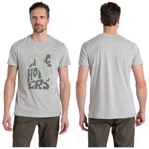 A gray t-shirt featuring the text "CRAG HOPPERS" in large, stylized font is worn by a man standing in a neutral space with no background distractions.