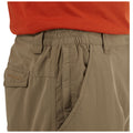 Tan cargo shorts with an elastic waistband are being worn by a person dressed in an orange shirt showcasing the side view of the shorts and the pocket detail.