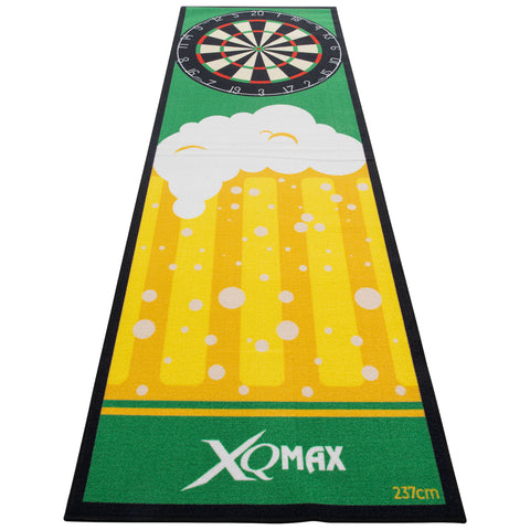 A long green mat features a dartboard at the top and a large beer mug with foam at the bottom surrounded by yellow stripes and bubbles. The mat is branded with XQMAX.