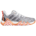 A grey athletic shoe with orange and white accents features a textured upper and a distinctively shaped sole designed for performance in active environments such as gyms or outdoor sports.