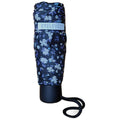 A floral-patterned umbrella, tightly folded and secured, rests vertically on a surface. It features a black handle with a rope attached for easy carrying, designed for protection from rain.