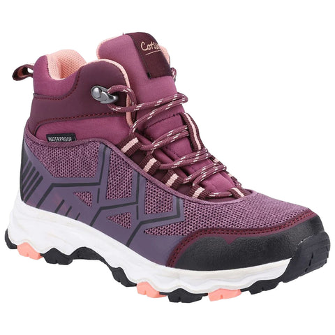 A waterproof hiking shoe features a deep purple design with mesh and synthetic materials highlighting its rugged sole and sturdy ankle support in a neutral white and pastel pink setting.