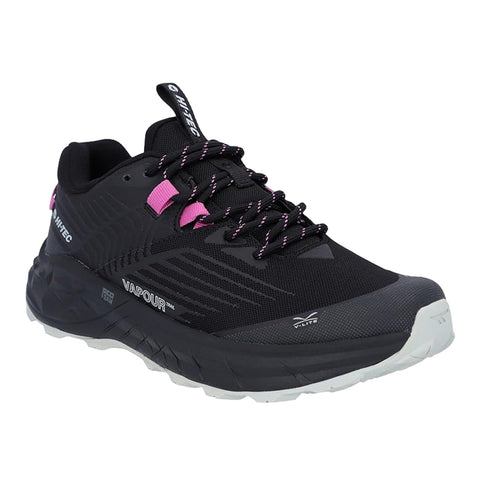 A black athletic shoe features pink accents and is designed for trail use showcasing textured surfaces a robust sole and laces indicating functionality for outdoor activities.