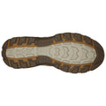 A shoe sole with rugged tread patterns is displayed resting flat against a white background indicating its design for traction and stability in outdoor environments