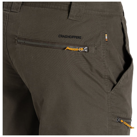 A pair of olive green trousers features multiple zippered pockets the brand name Craghoppers is stitched above one pocket highlighting a practical design for outdoor activities.