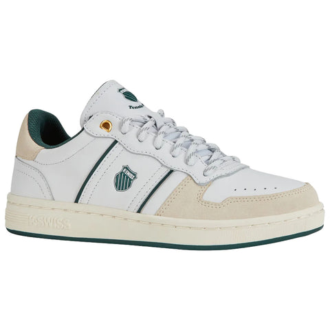 A white sneaker with green accents and a suede toe features laces and a logo on the side, positioned on a neutral background, showcasing its sporty design.