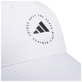 A white golf cap displays a circular black logo featuring three stripes and the text ADIDAS GOLF THE BRAND WITH STRIPES positioned around the logo emphasizing the brand's identity.