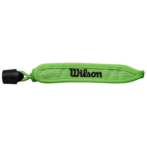 A bright green wristband marked with the word Wilson is lying flat against a plain background showcasing its woven texture and adjustable closure mechanism at one end.