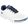 A white golf shoe with navy accents is displayed facing forward showcasing its sleek design and textured surface with a spiked sole meant for traction on grass.