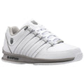 A white athletic shoe is positioned at an angle showcasing its sleek design and laced front resting on a neutral background emphasizing its clean appearance and modern style