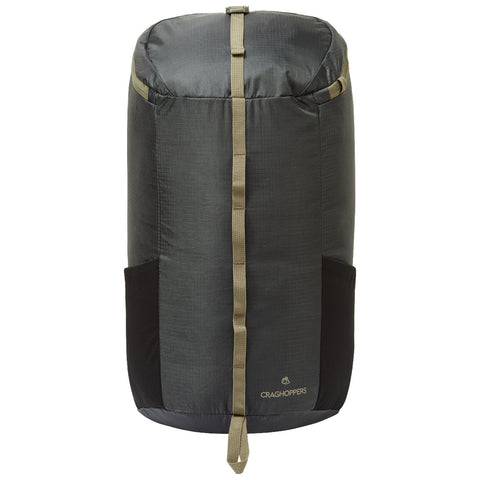 A cylindrical backpack stands upright with a dark fabric body and lighter straps. It features side pockets and a branded logo at the bottom, suitable for outdoor activities.