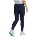 Tight navy leggings are being worn by a person walking away, showcasing a high waistband and a pair of light athletic shoes with colorful details in a neutral setting.