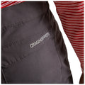 Gray fabric shorts are displayed with a logo reading CRAGHOPPERS stitched on the pocket beside a person wearing a red and white striped long-sleeve shirt in a close-up view