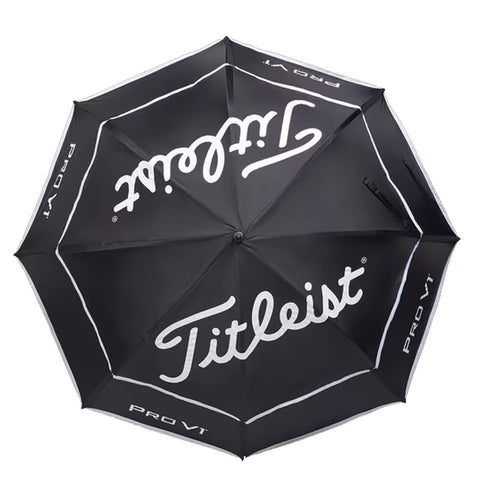 A black golf umbrella with white lettering opens wide providing coverage featuring the brand Titleist and the model Pro V1 creating a stylish protective canopy for players.