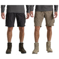 Two pairs of cargo shorts are displayed side by side one in black and the other in khaki worn by a person in gray long sleeves standing in military-style boots.