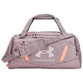 A gray duffel bag sits upright featuring a large Under Armour logo and orange accents with a detachable shoulder strap and dual top handles designed for carrying sports gear in various settings.