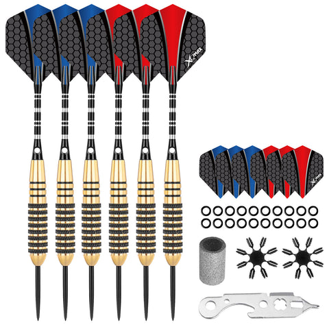 Six steel-tipped darts with black and gold barrels are arranged vertically with red and blue flight pieces beside them. Additional accessories like O-rings and a multi-tool are included.