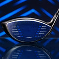 A golf club head is displayed prominently showing a sleek black and blue design with a perforated face and a glossy finish reflecting light against a geometric blue background.